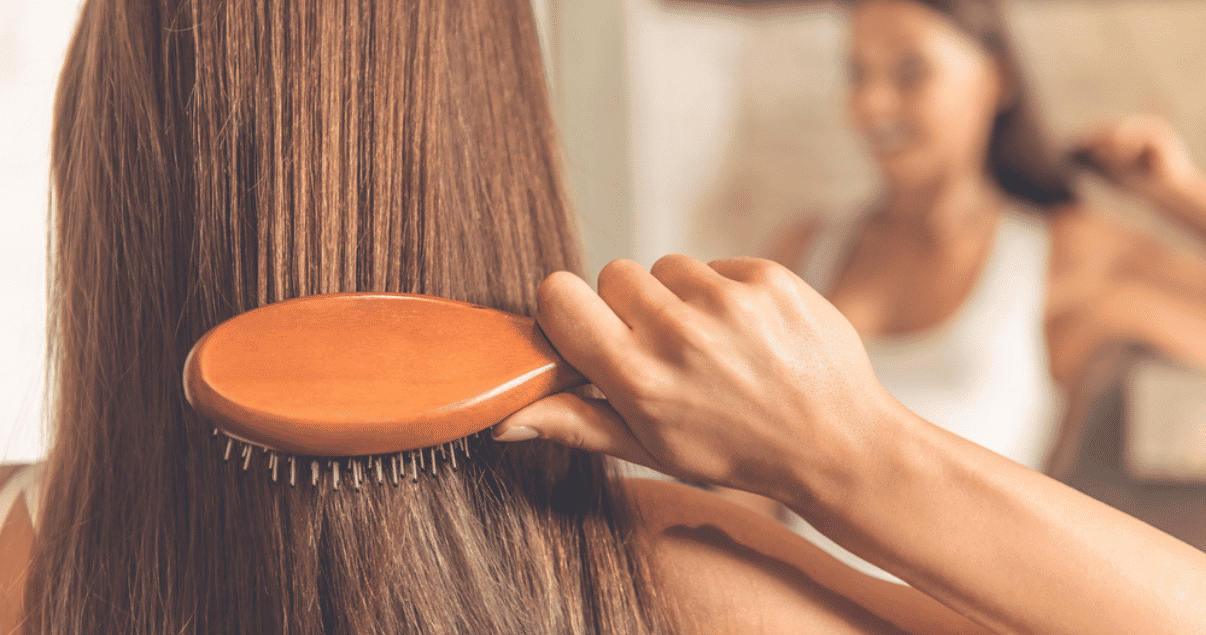 Middle aged woman brushing hair before storing wig